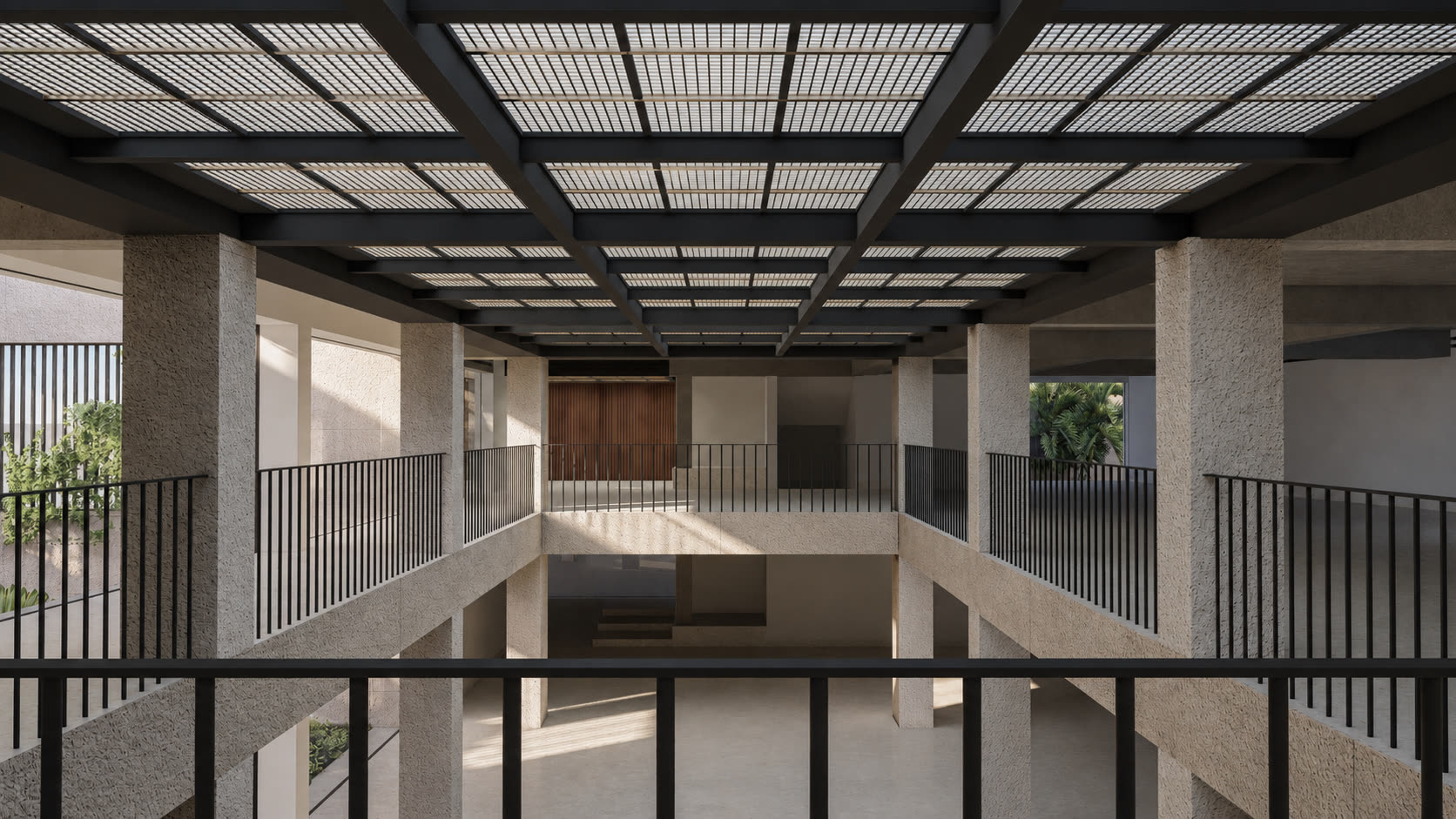 Upper walkway overlooking the double-height atrium, with a textured concrete column, black railings, and a skylight grid.