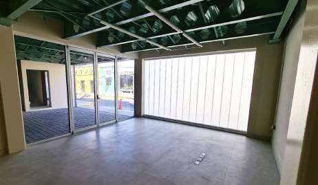 Interior of D1AS: open office floor, cellular steel beams, translucent glass wall, and tiled floor.