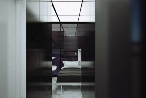 Compact bedroom seen through a dark doorway: a low bed, white pillow, and a ceiling grid of light panels.