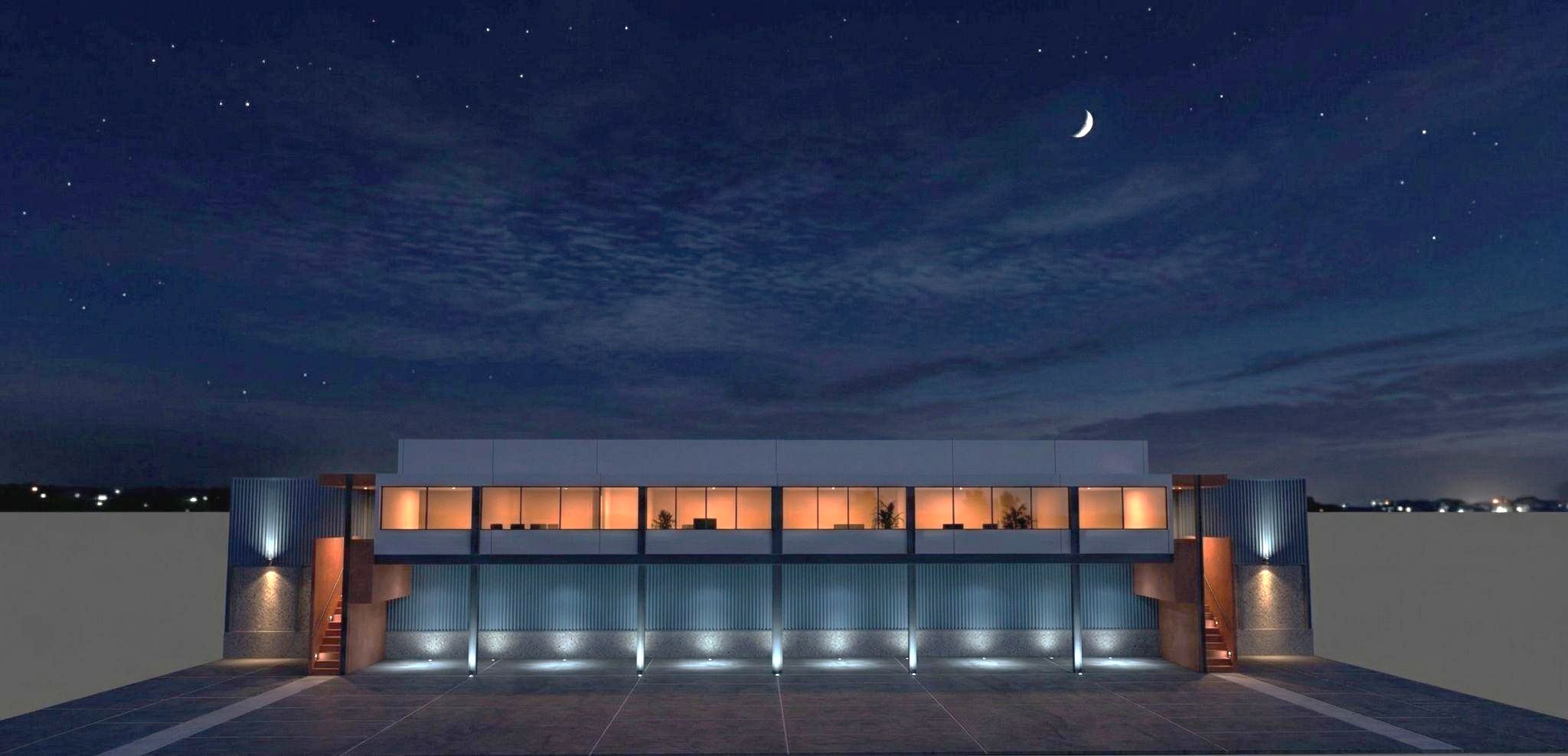 Night render of the elevated warehouse and office: corrugated warehouse at truck level behind columns with uplights, a lit white office strip, and terracotta stair volumes at both ends.