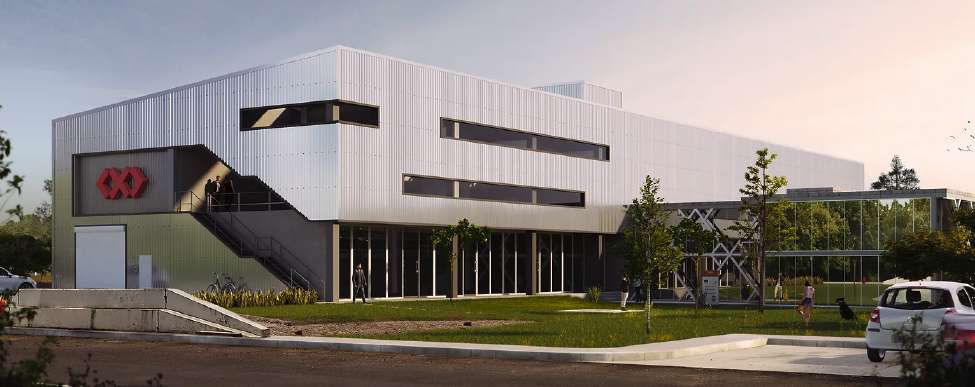 TARA mixed-use building with silver corrugated metal siding, ribbon windows, an external stair, and a red chevron logo.